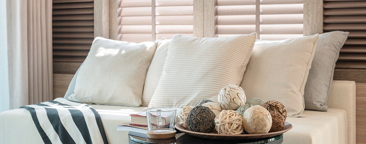 White blinds over a sofa with cushions