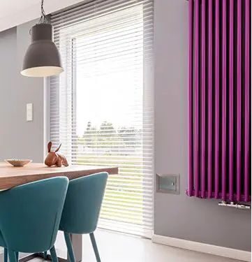 Blinds beside a purple curtain in a dining room